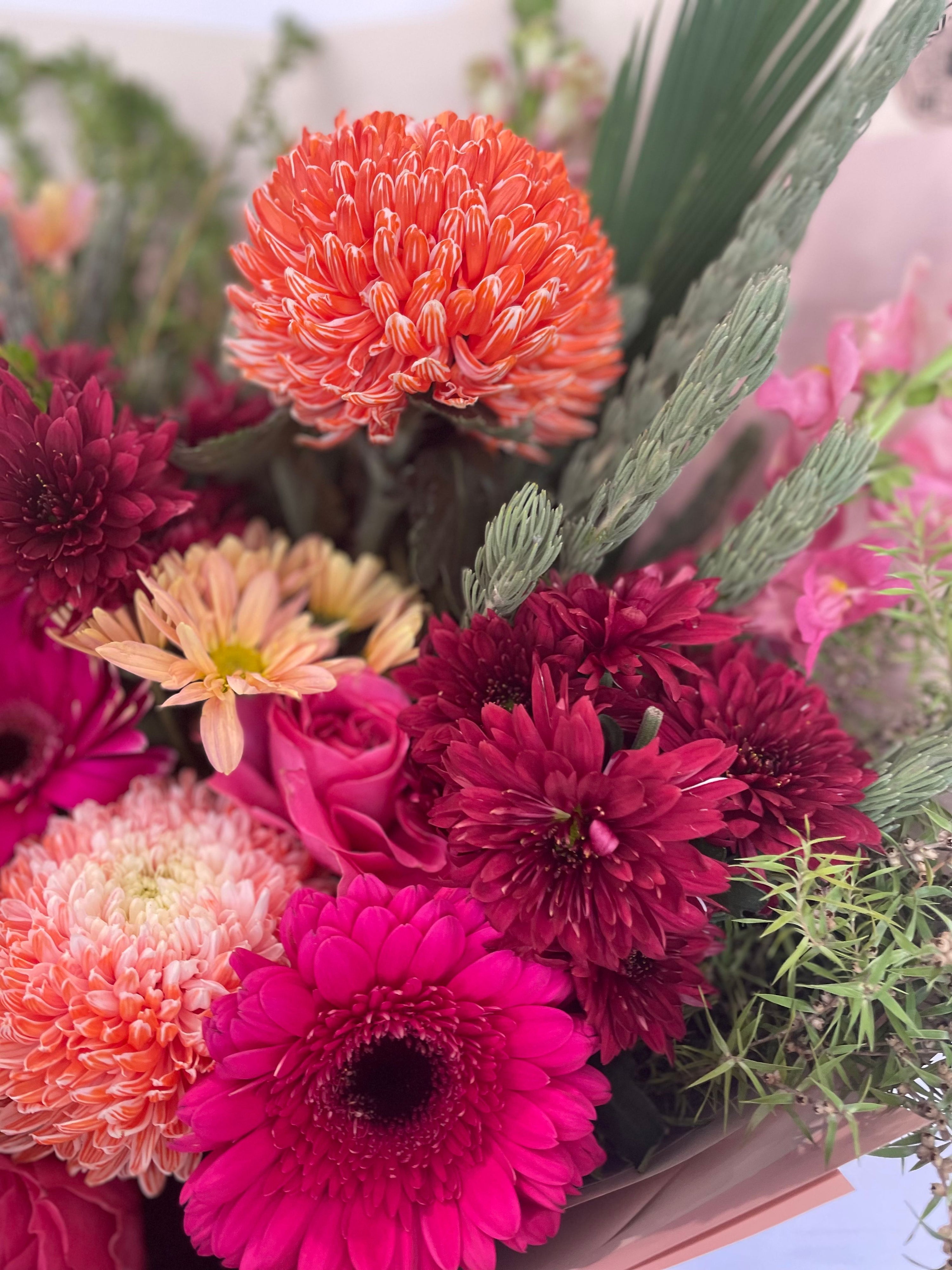 Deluxe Cherry Spice bouquet with vibrant hot pink gerberas, orange disbuds, burgundy chrysanthemums, and soft peach roses, handcrafted by The Flower Boutique Perth — available for same-day flower delivery across Perth.