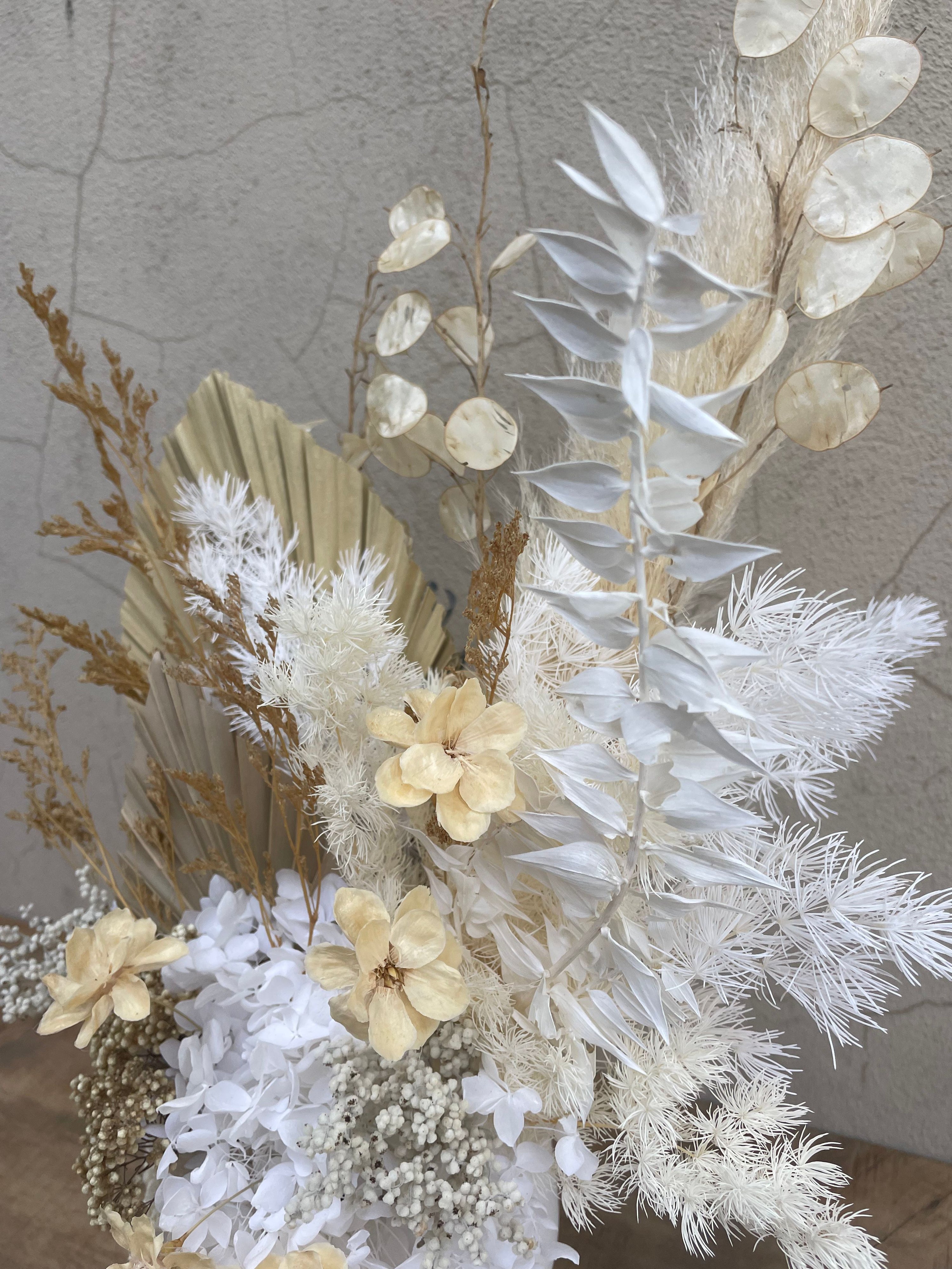 Arrangement of dried flowers and leaves on a textured surface