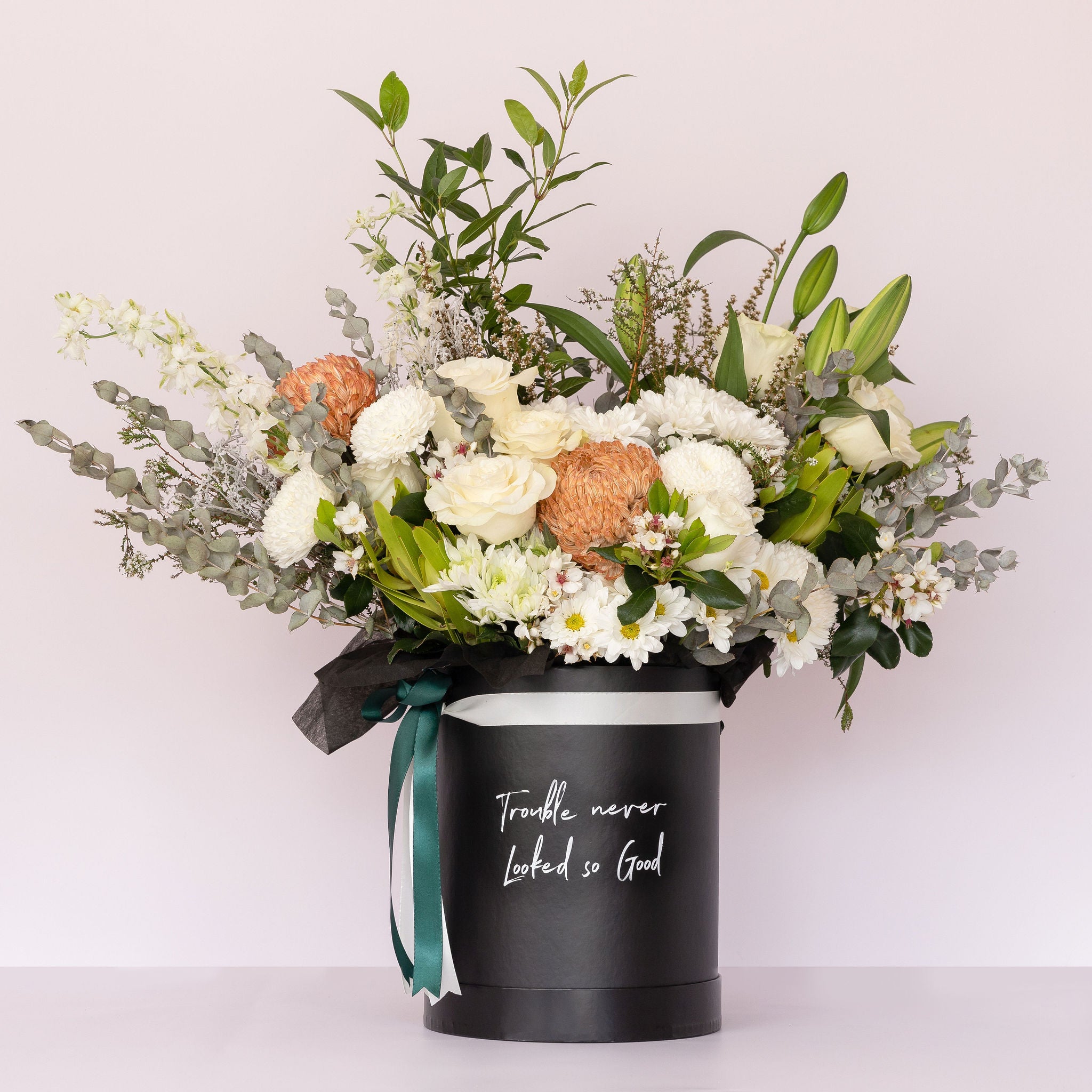 Luxury flower box featuring soft neutral-toned blooms in a sleek black keepsake box, perfect for special occasions or gifts.