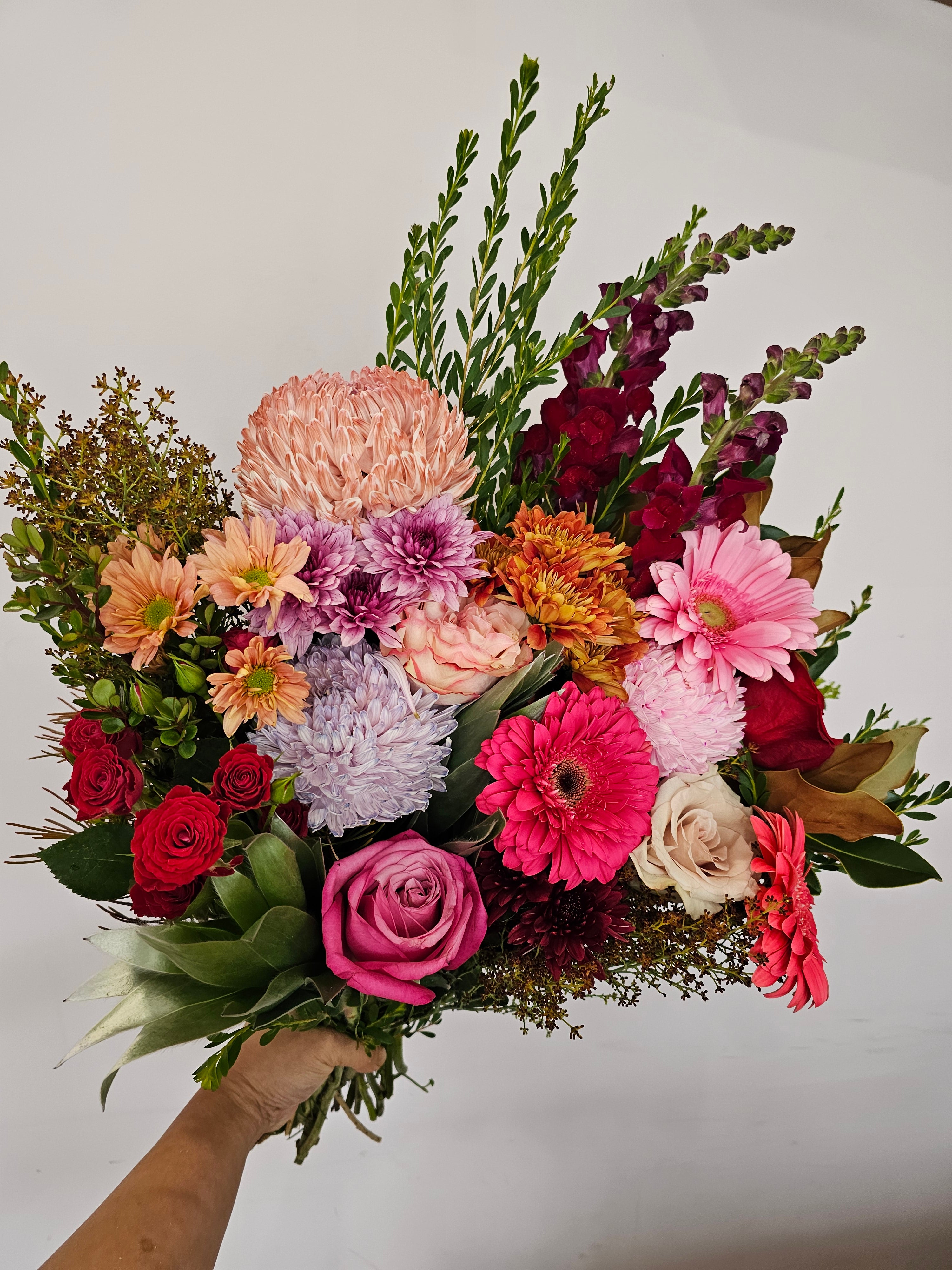 Floral Fiesta bouquet featuring vibrant orange, pink, red, purple, and cream flowers, available for delivery in Perth, Western Australia.