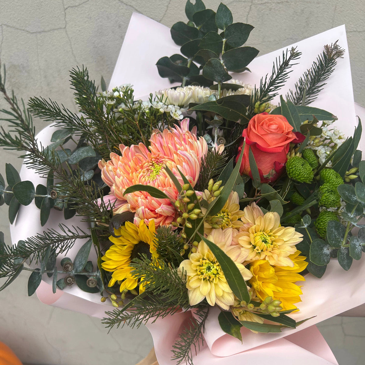 1. Bright Posy viewed from above, showing colourful seasonal flowers and eucalyptus in gift wrapping