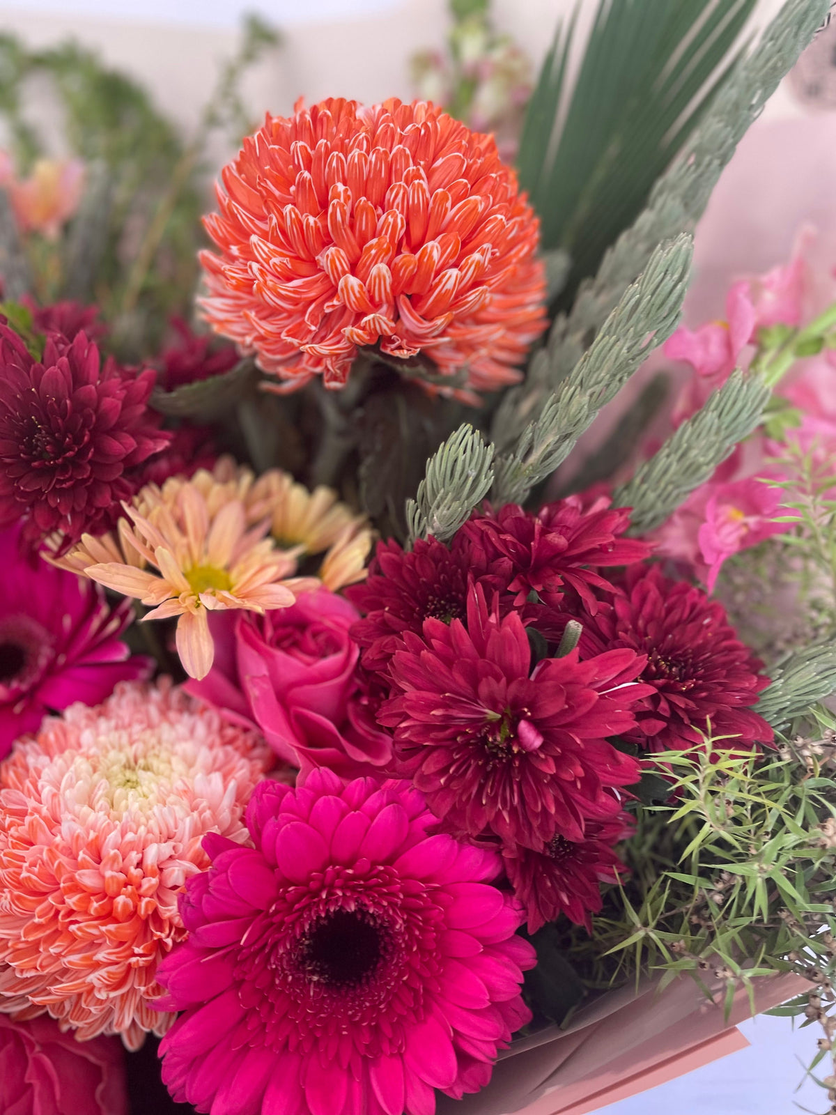 Deluxe Cherry Spice bouquet with vibrant hot pink gerberas, orange disbuds, burgundy chrysanthemums, and soft peach roses, handcrafted by The Flower Boutique Perth — available for same-day flower delivery across Perth.
