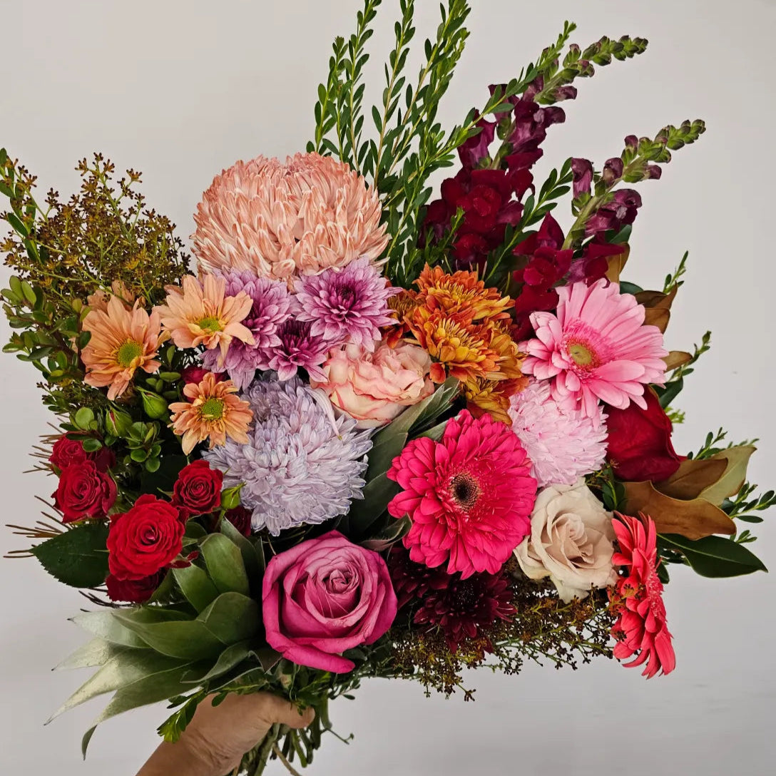Floral Fiesta bouquet featuring vibrant orange, pink, red, purple, and cream flowers, available for delivery in Perth, Western Australia.