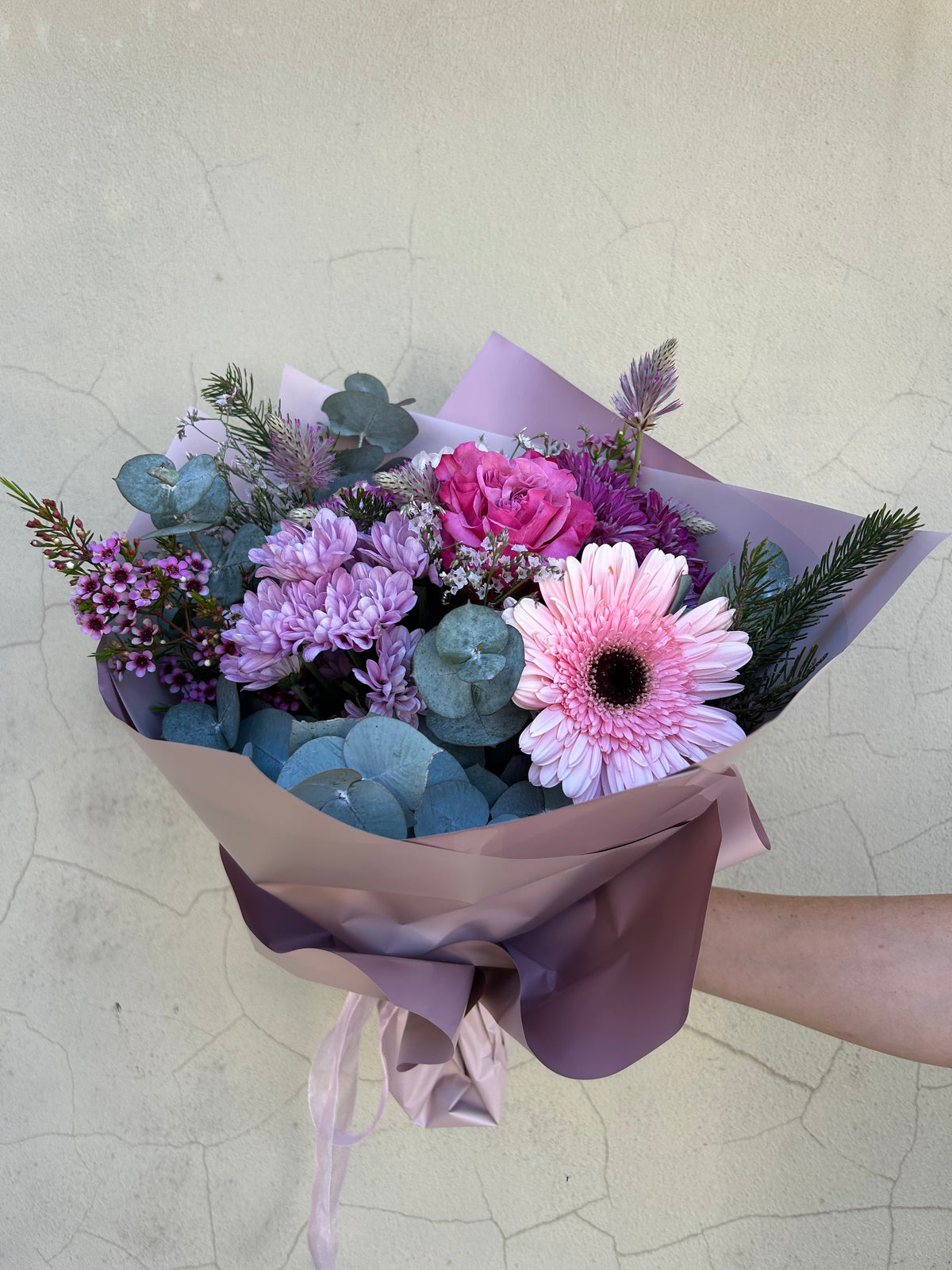 Florist’s Choice bouquet with pink, purple and white seasonal flowers in mauve wrapping