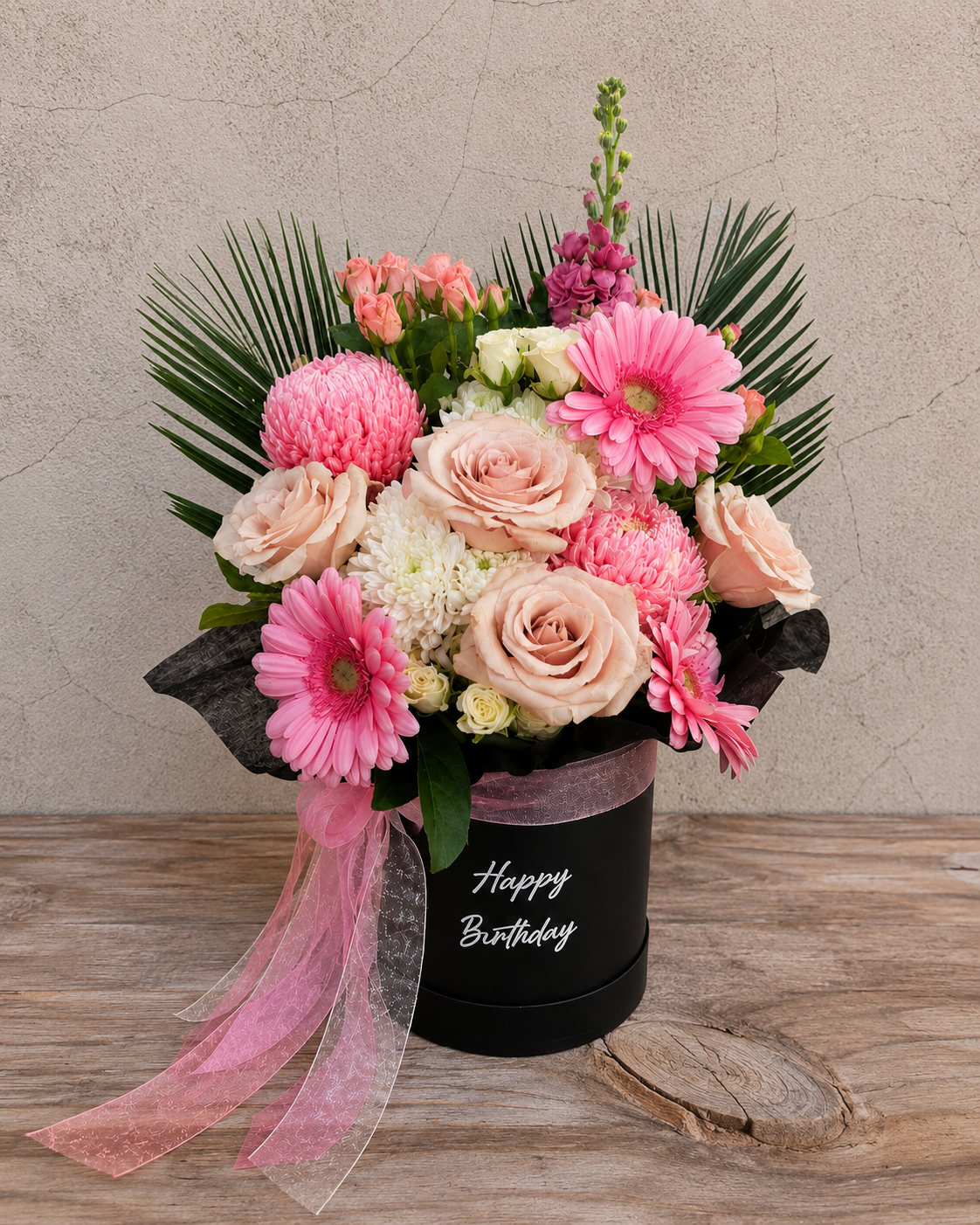  Deluxe blush pink flower box in a black keepsake hatbox with “Happy Birthday” written in elegant script, perfect for birthday celebrations.