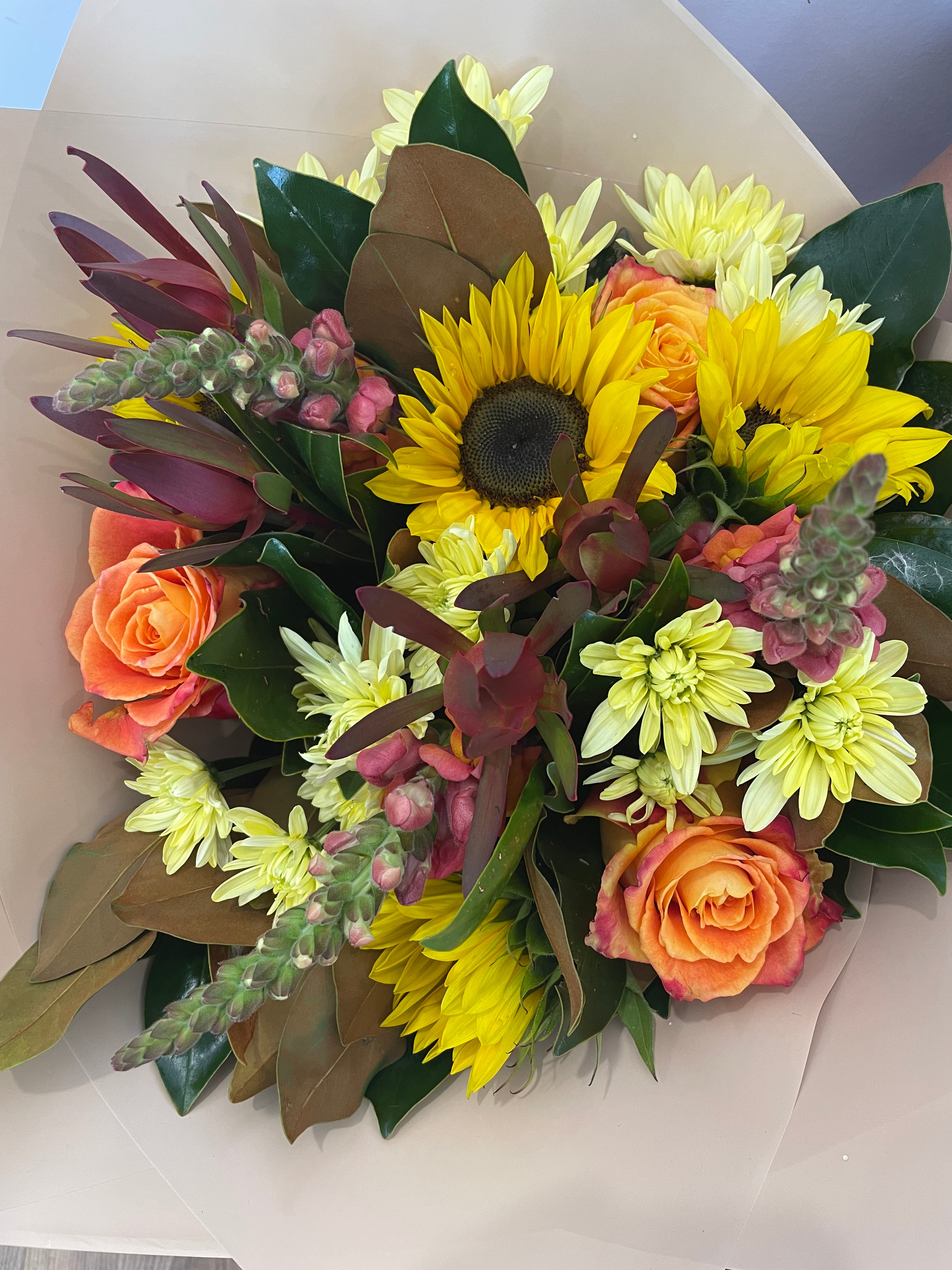 "Warm-toned flower bouquet with vibrant yellow, orange, and red blooms, perfect for any occasion. Available for same-day delivery in Perth from The Flower Boutique, your expert local florist for unique, handcrafted floral arrangements.