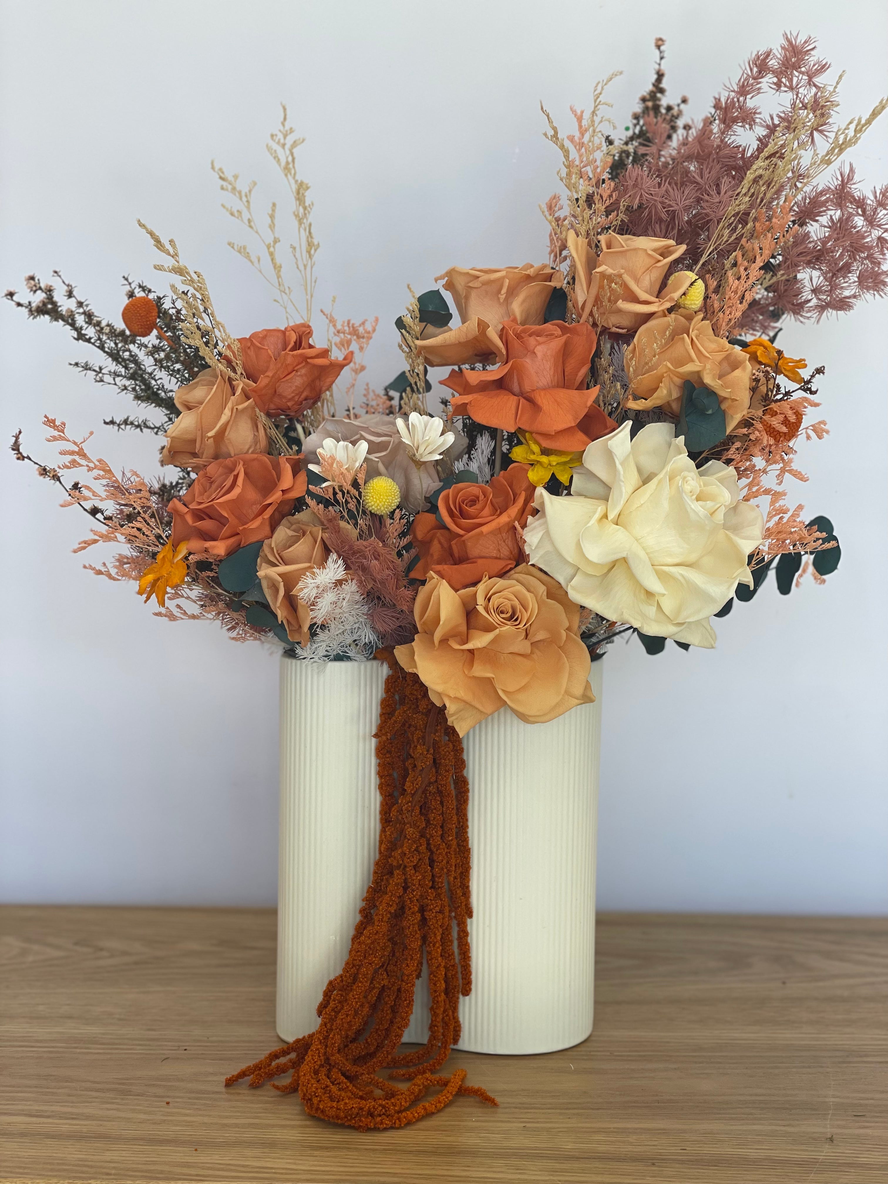 Preserved flower arrangement in vibrant tangerine and soft orange tones, elegantly displayed in an orange ceramic pot, standing, perfect for sustainable home decor.