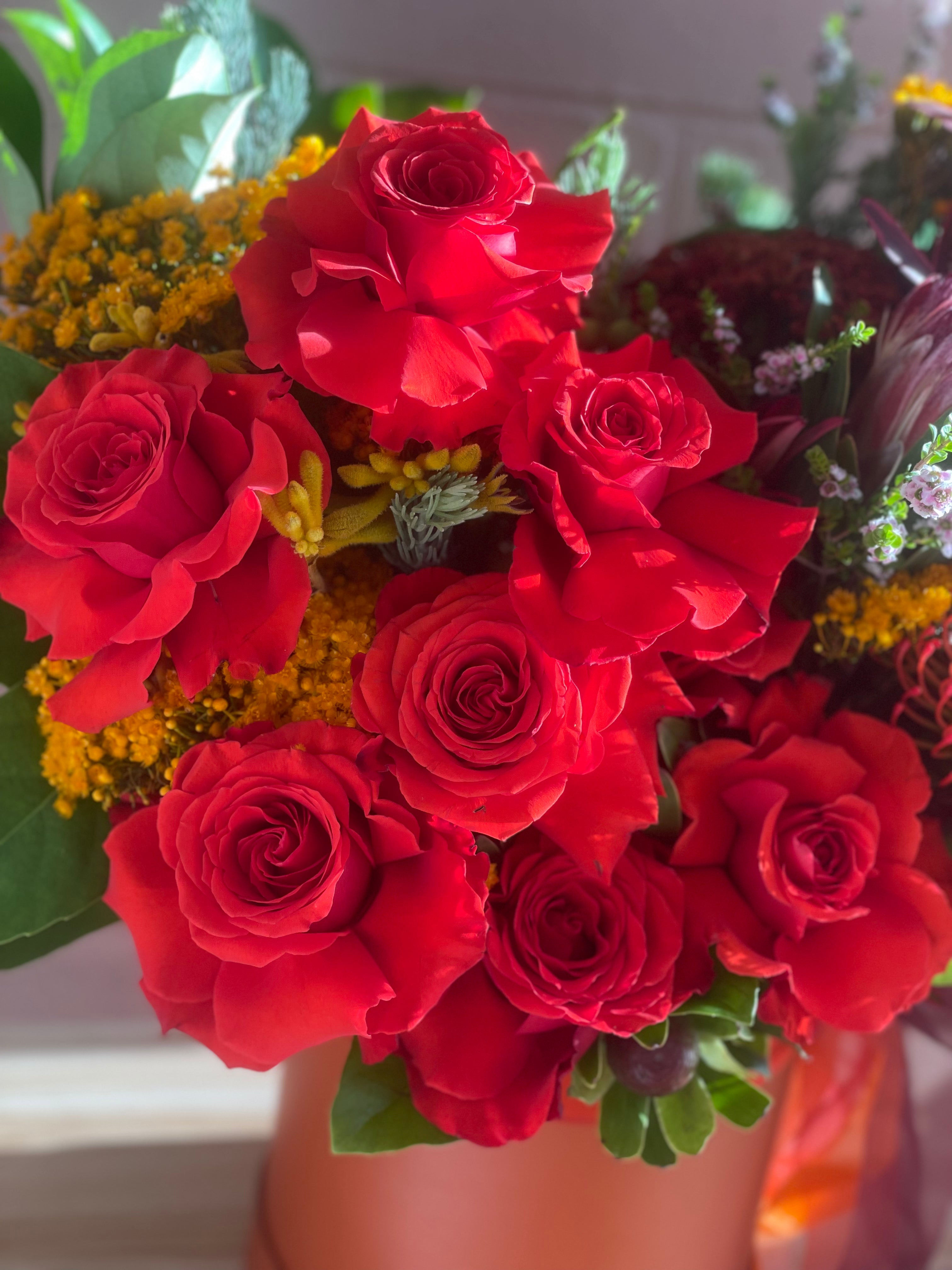 Close-up of roses in the Christmas Natives Flower Box, Tangerine-coloured Christmas Flower Box with native Australian blooms