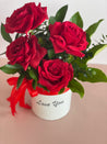 VIDA flower box with a lovely red ribbon and bright green folliage featuring four beautiful premium Ecuadorian roses in a white keepsake box.