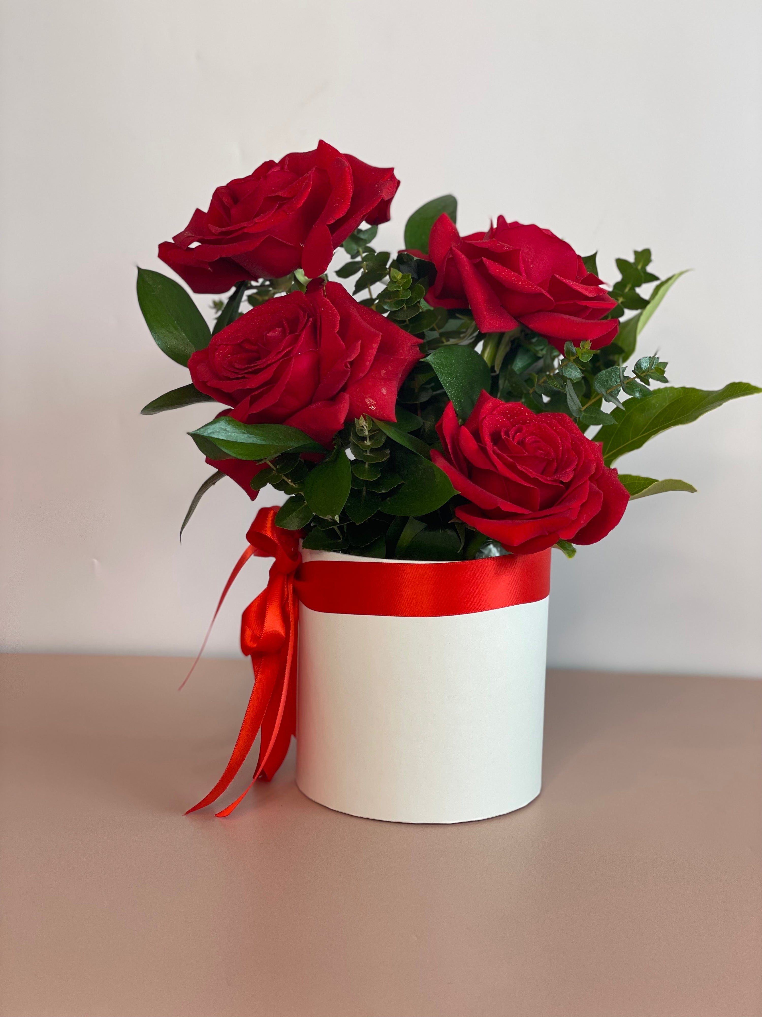 VIDA flower box featuring a red ribbon and four premium Ecuadorian roses in a white keepsake box.