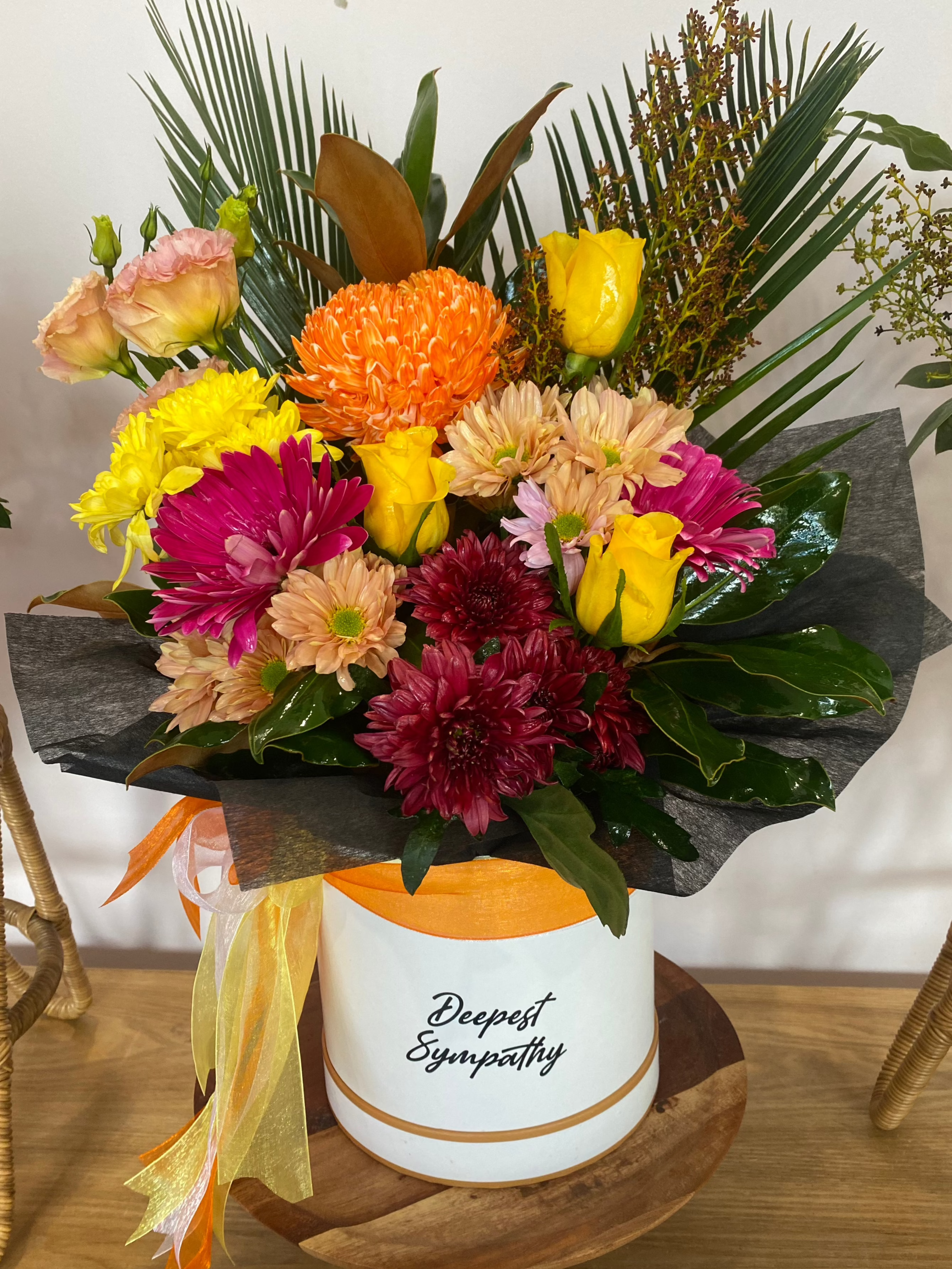 White flower box with bright and colourful blooms, designed for deepest sympathy, offering comfort and support in a stylish hatbox.