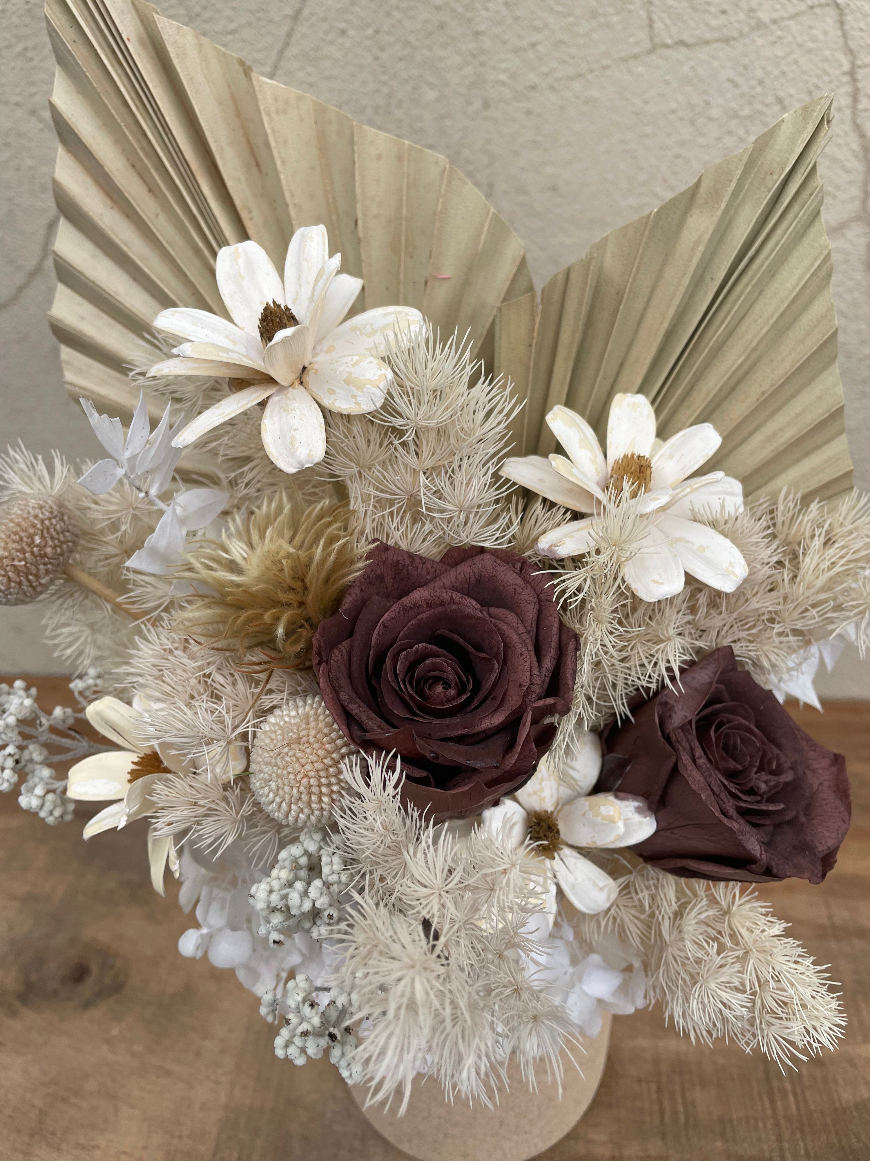 Bouquet of dried flowers with white and brown tones on a neutral background