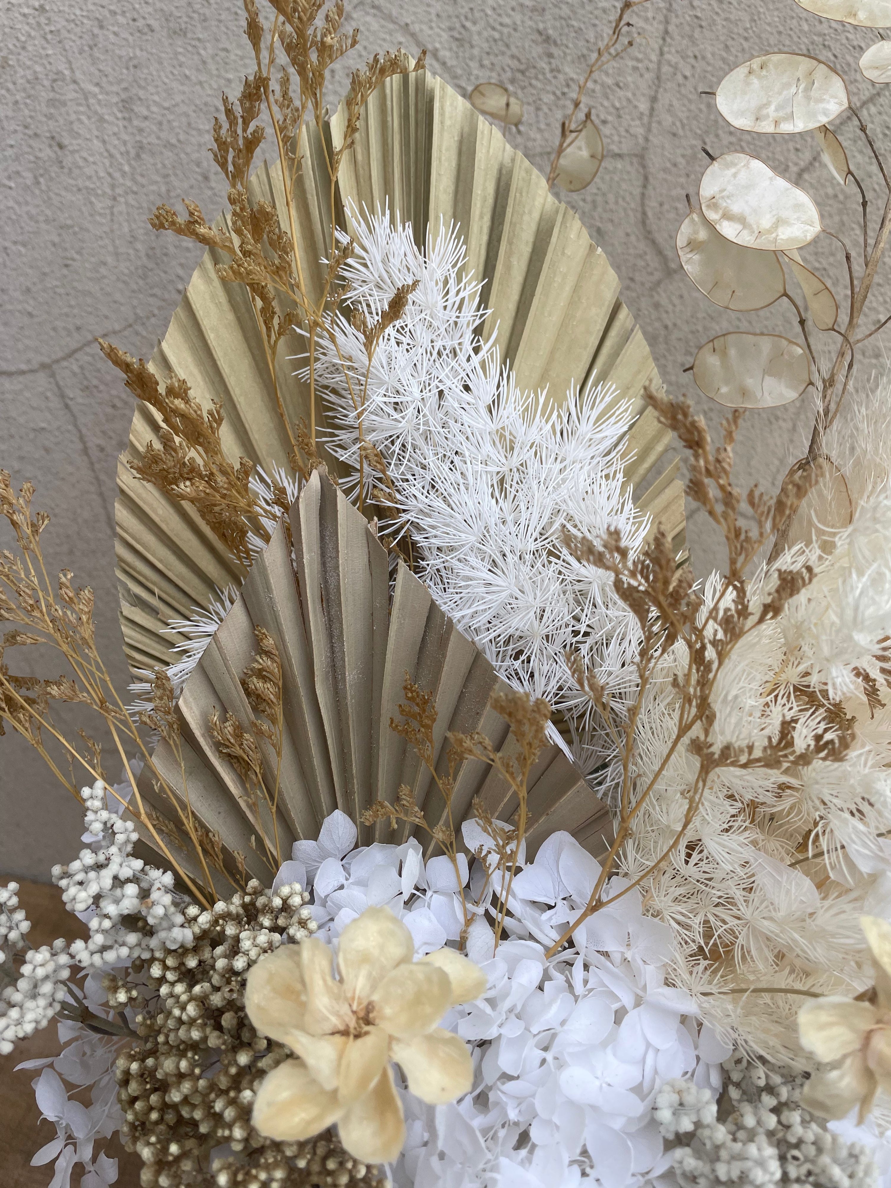 Decorative arrangement of dried flowers and leaves on a textured. order dried flowers for delivery accross Perth 
