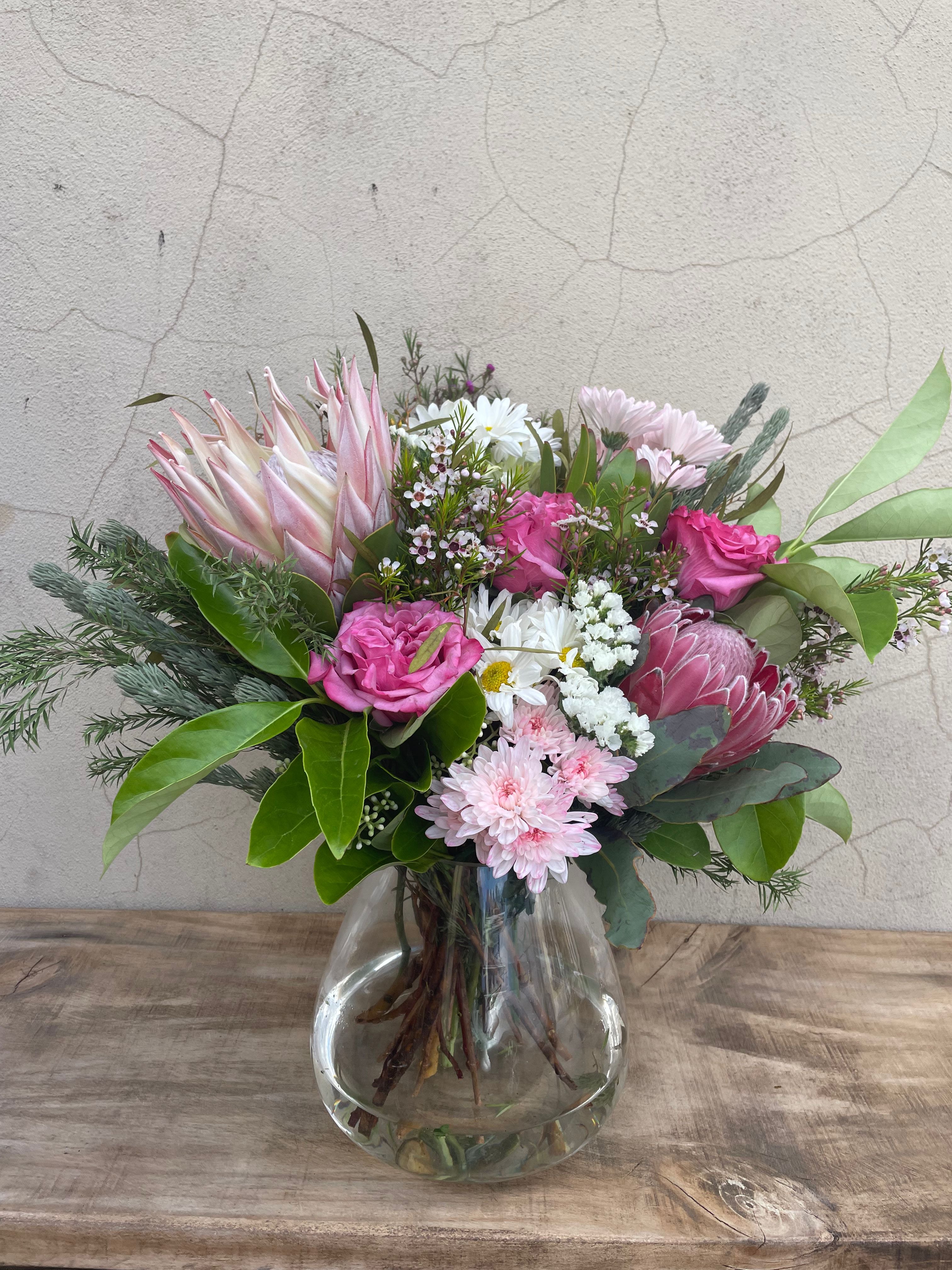 Bouquet of pink and white flowers in a clear glass vase on a textured surface. Our fresh flower subscriptions are available for weekly, fortnightly or monthly for delivery from The Flower Boutique Perth