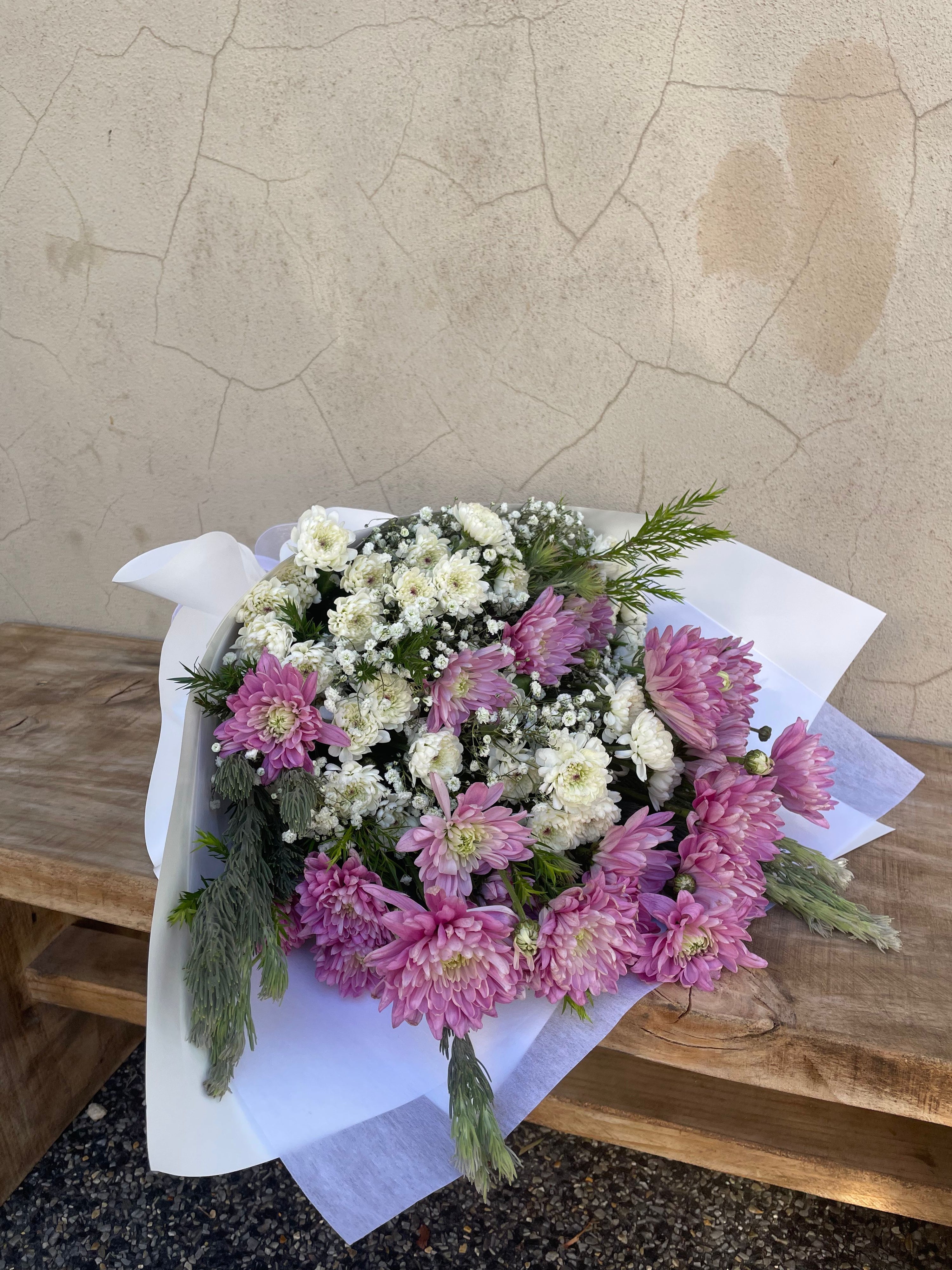 Bouquet of pink and white flowers on a wooden surface with a concrete background. fresh Flowers available for pick up from our tapping studio or delvery accross Perth by Riana Bertolami from The Flower Boutique