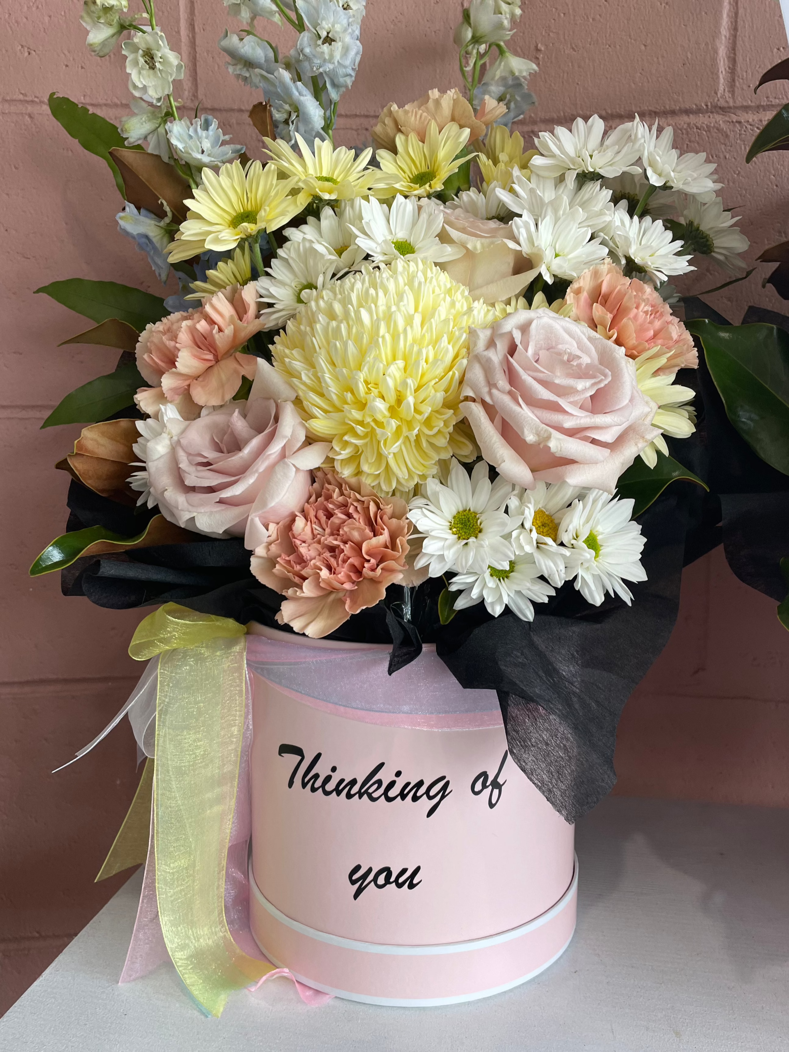 Standard pink flower box in a keepsake hatbox with "Thinking of You" written in elegant script, perfect for sending a thoughtful message.