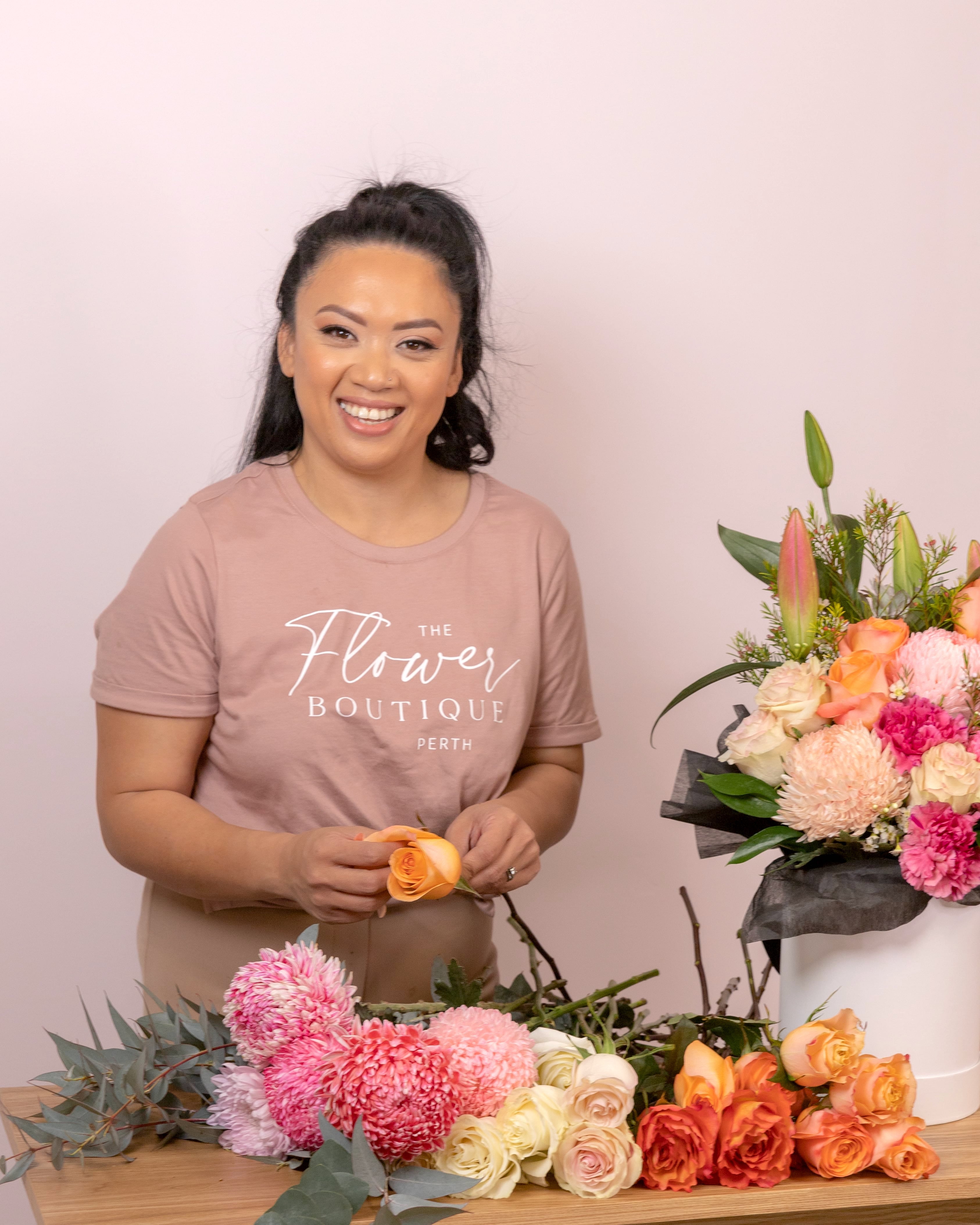 Riana Bertolami owner of The Flower Boutique creating Flowers non a table in her local florist shop. Riana offers all kinds of floral services including Perth Flower Delivery, Box of flowers, bouquets, dried arrangements, events and wedding flowers
