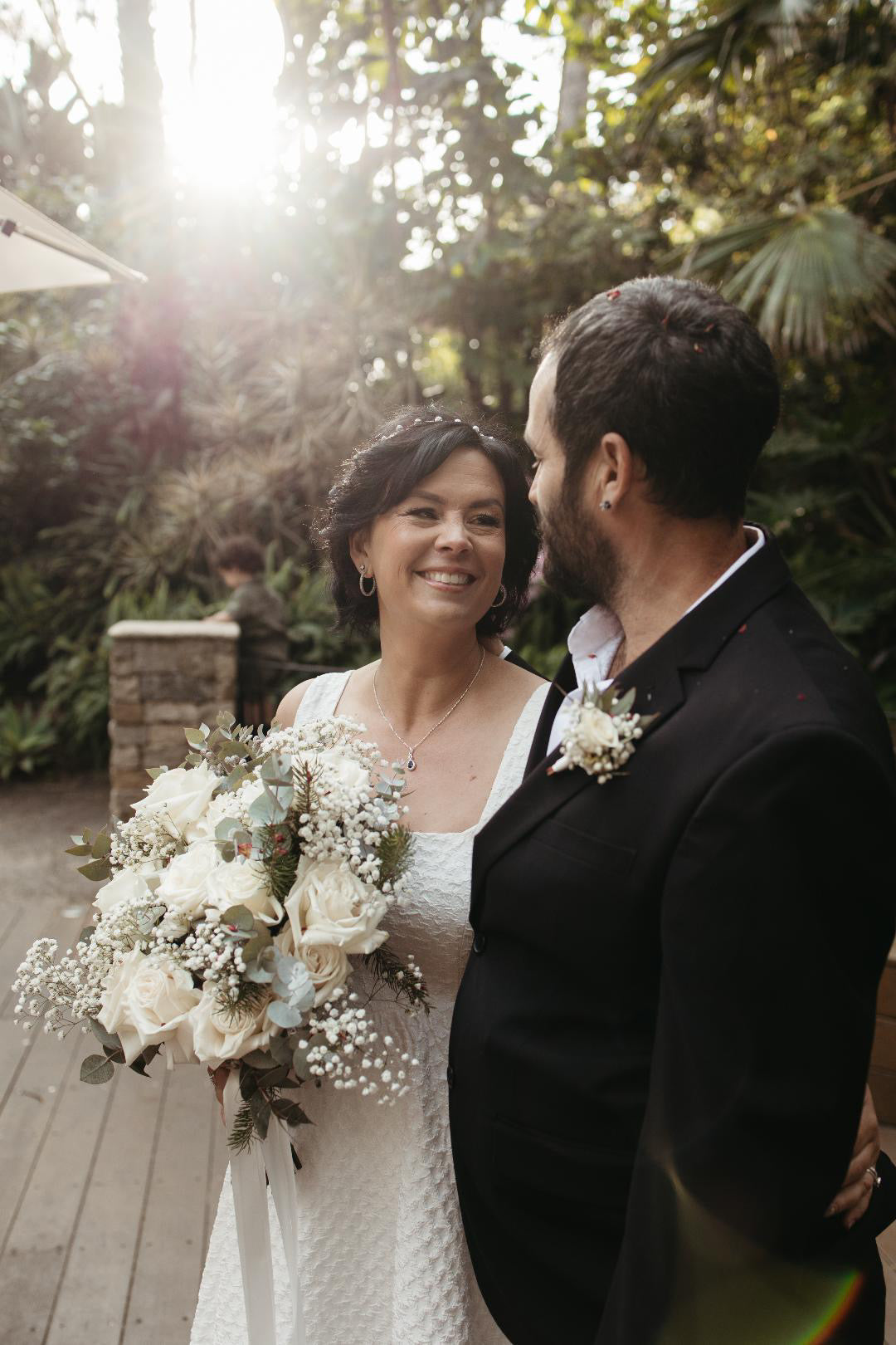 Wedding couple standing outdoors with a bouquet of flowers. At The Flower Boutique our expert florist Riana Bertolami brings any event to life whether it's a Wedding or Funeral or Corporate event we can assist with your flowers. Located in Ashby, Perth 6065