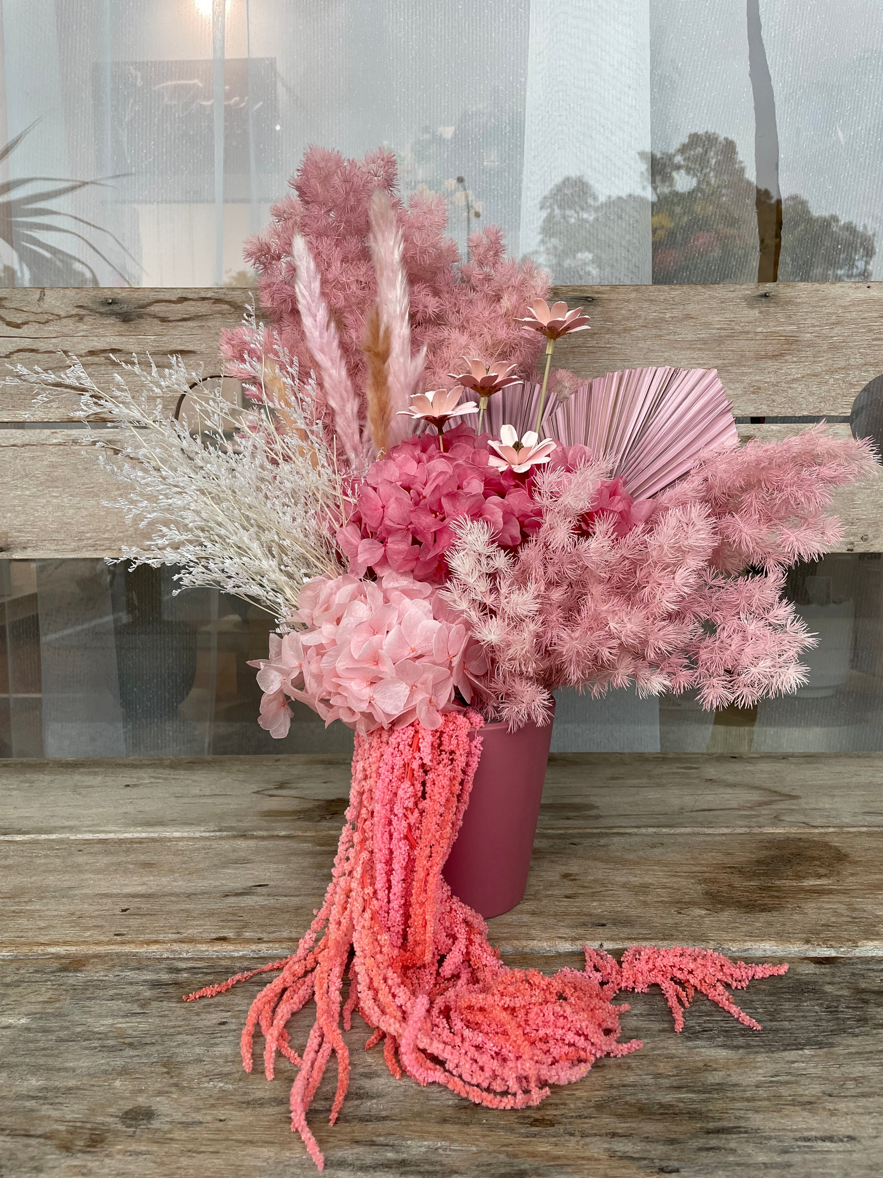 Preserved flower arrangement standing approximately 45cm tall in a deep pink ceramic pot, featuring a soft variety of nude pinks. Adds a delicate charm to the corner of a quiet living room or bedroom.