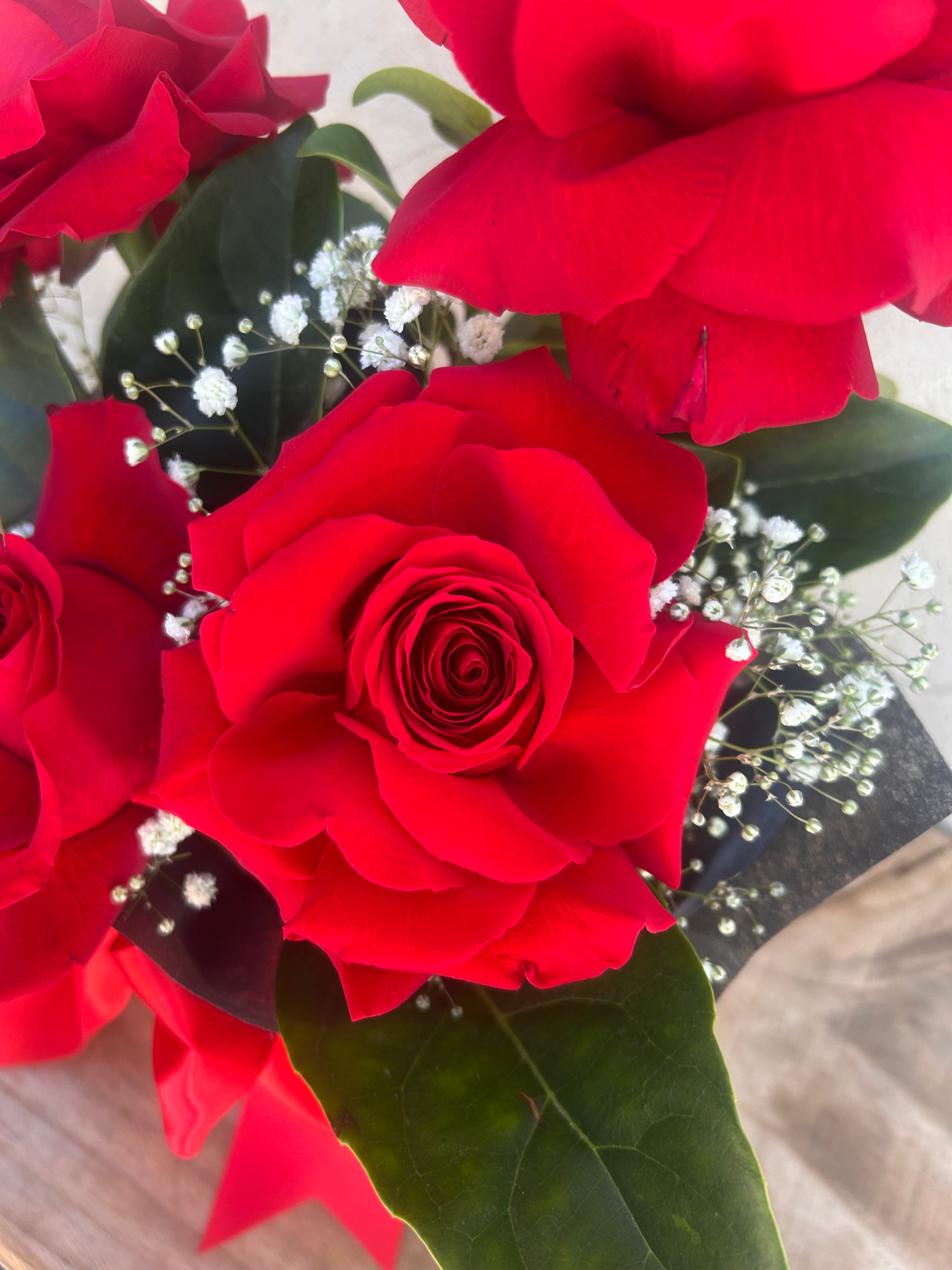 A red roses with green leaves and small white flowers for Perth flower delivery on valentines Day