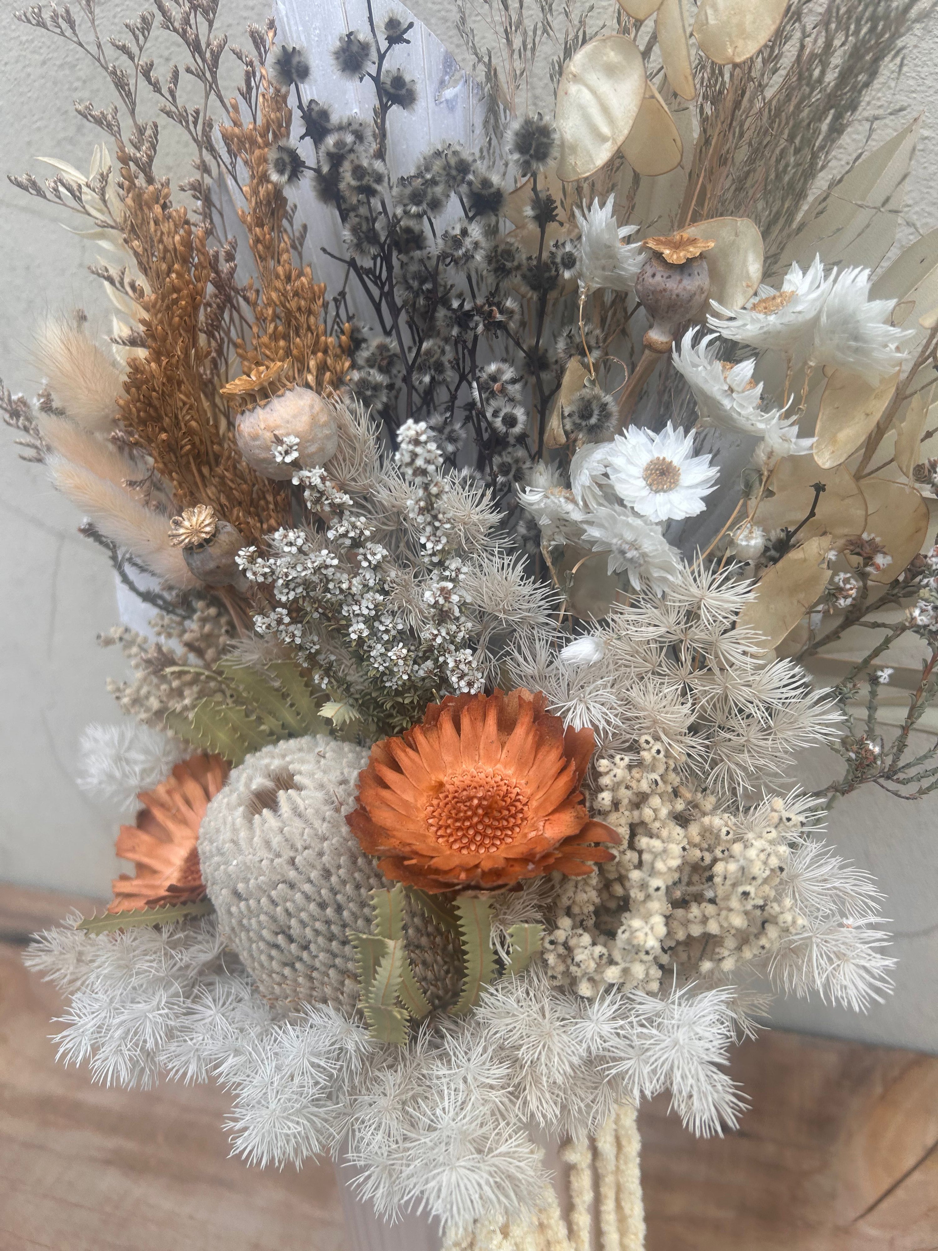 Vase of dried flowers with an orange flower in the center. Available for delivery from The Flower Boutique Perth