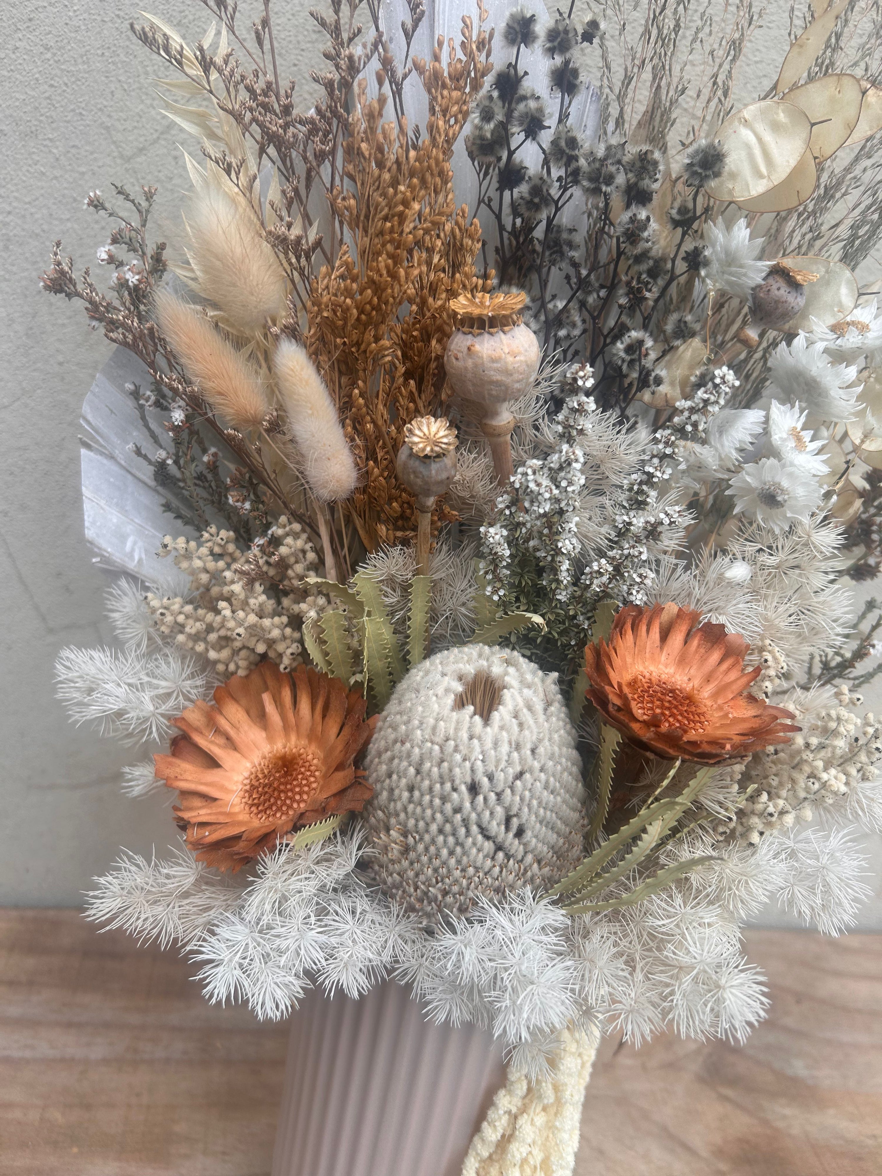 preserved flower arrangement with banksia and natural textures in vase