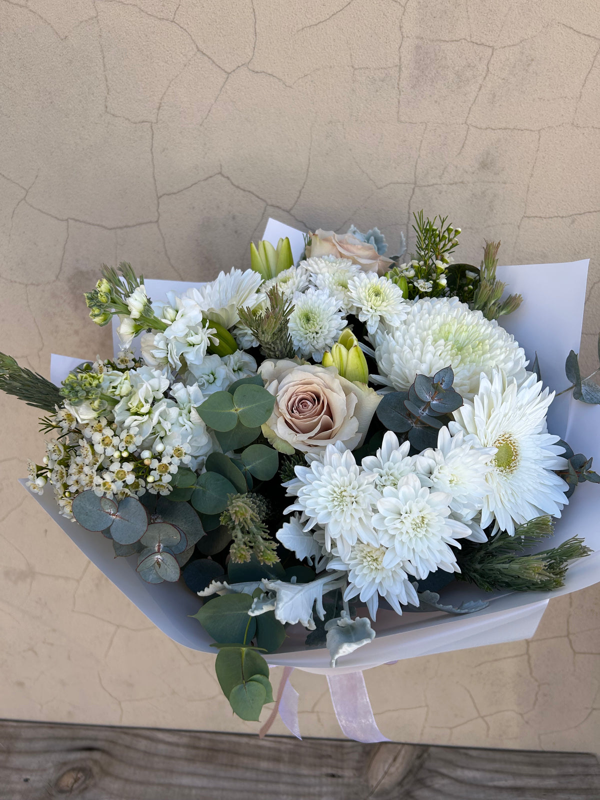 Simplicity bouquet showing white flowers, cream roses and greenery from above