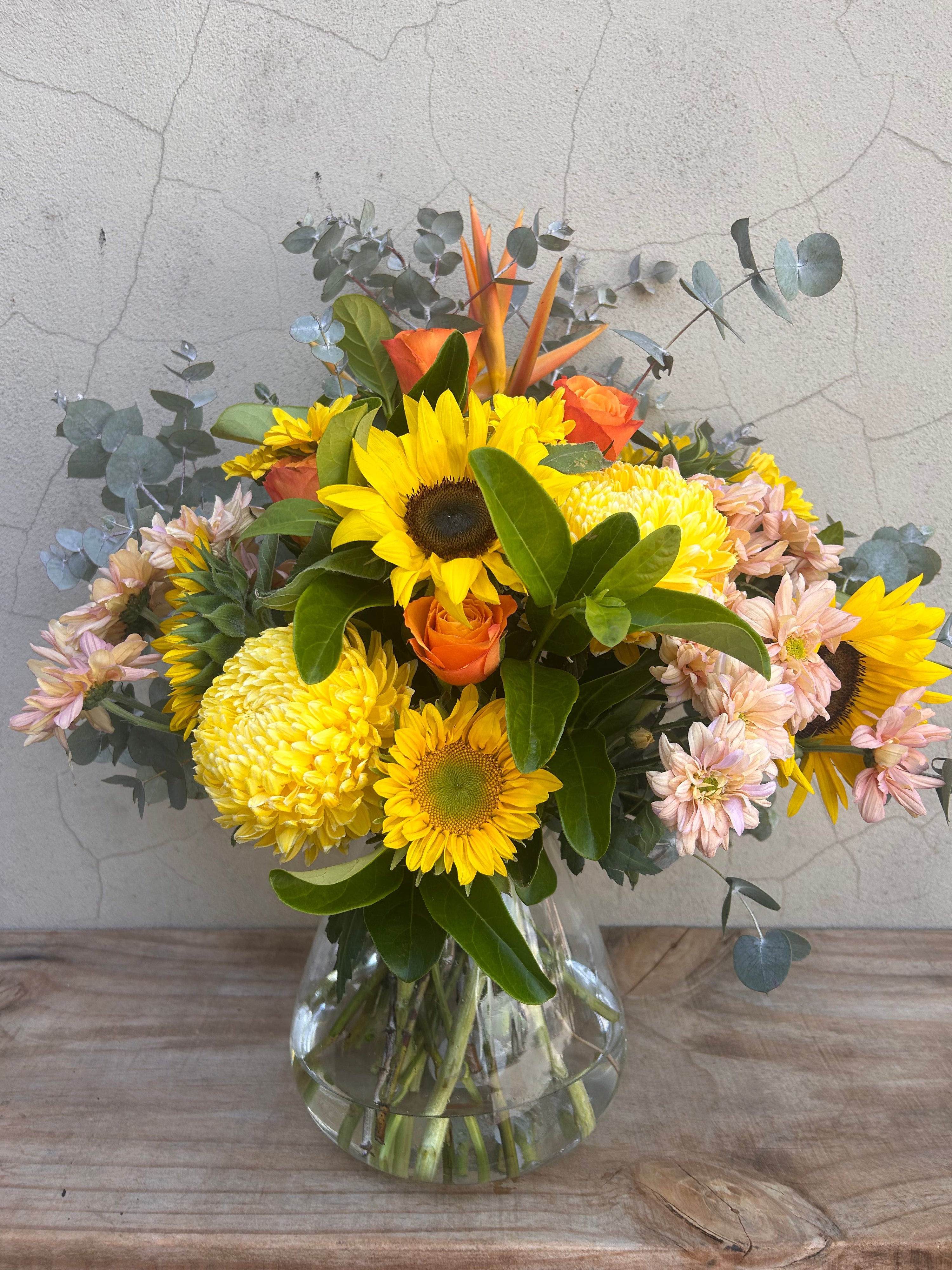 Sunflower vase arrangement with seasonal blooms in glass vase
