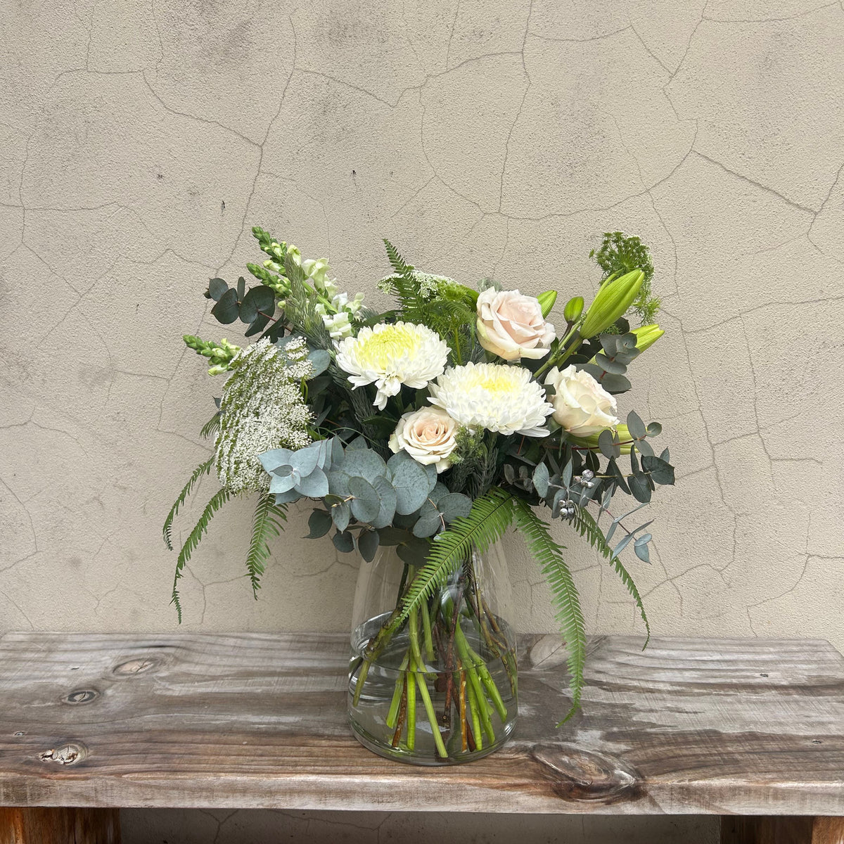 Grande Thinking of You sympathy arrangement with white chrysanthemums, cream roses and eucalyptus in a clear glass vase