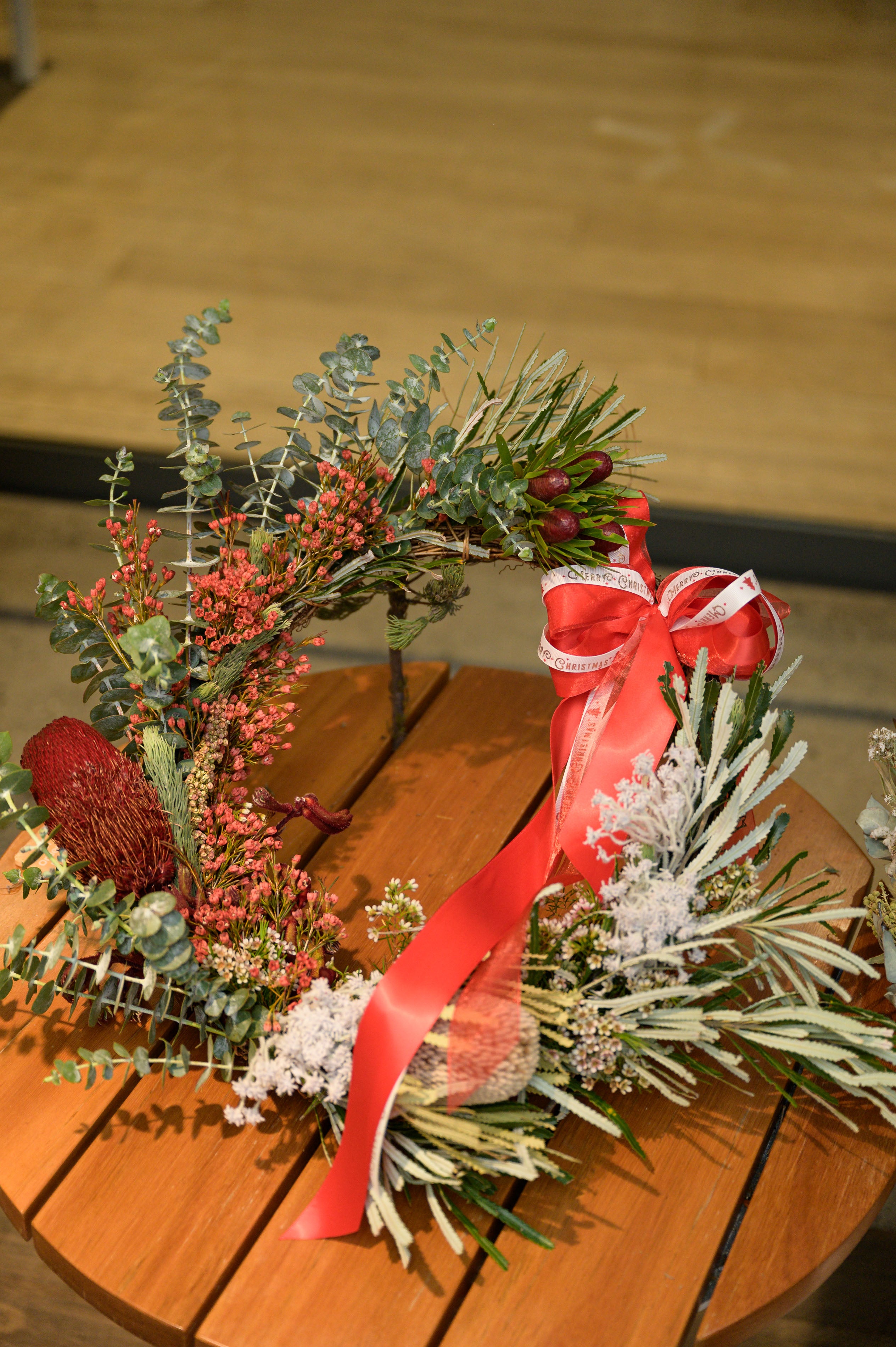 A beautifully handcrafted Christmas wreath made from fresh and dried seasonal greenery, decorated with festive ornaments and ribbons, perfect for adding a personal touch to holiday home decor. Crafted at The Flower Boutique's Christmas Wreath Workshop in Perth.