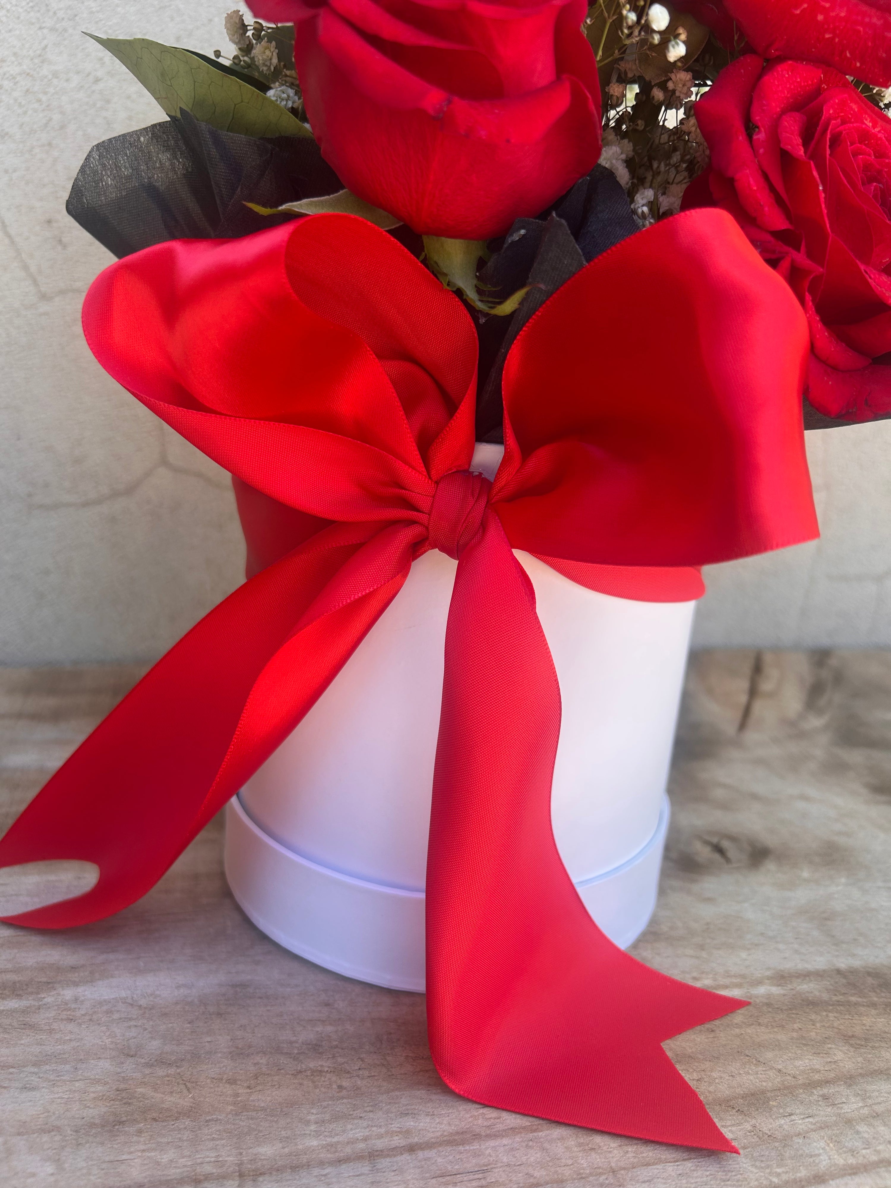 Red roses with a large red bow on a white box for Valentines Day delivery from The Flower Boutique Perth