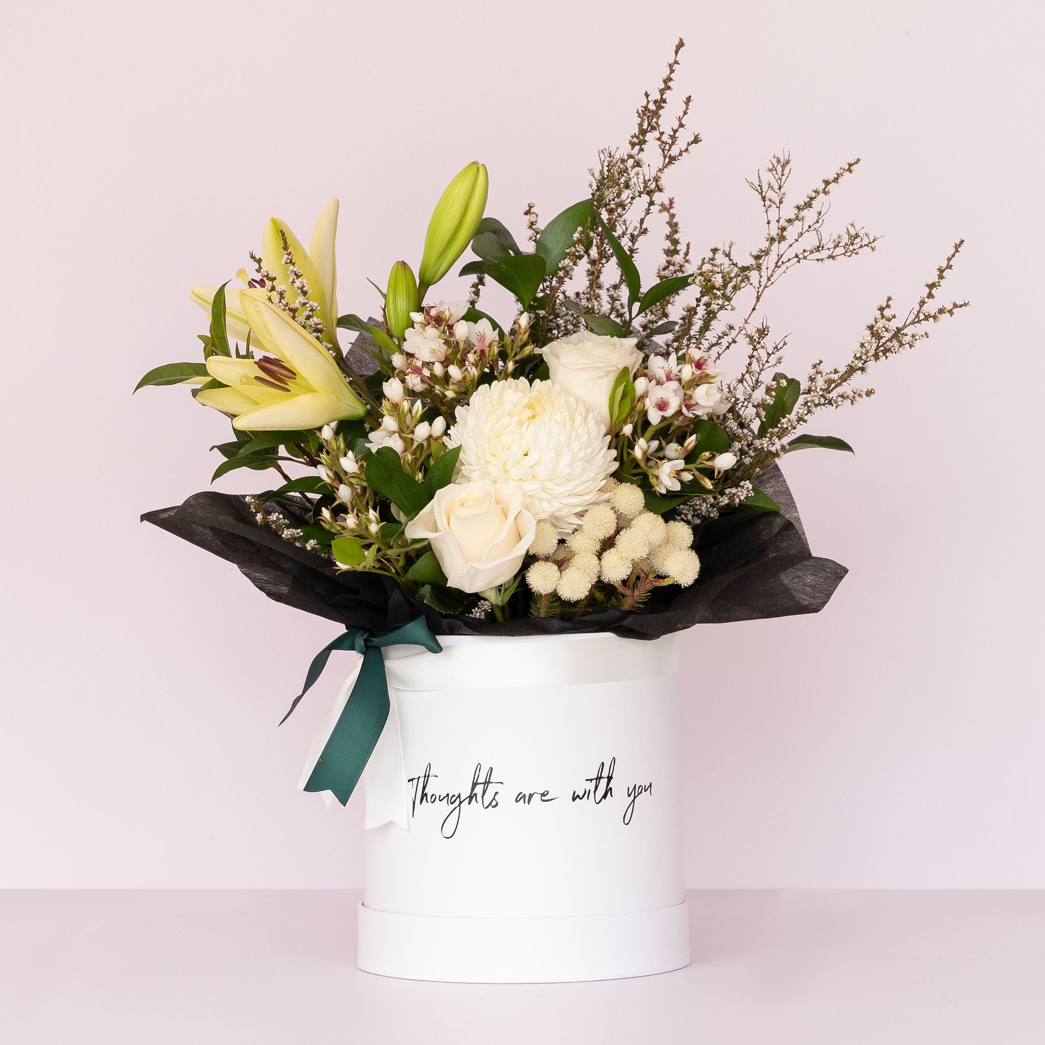 A Signature flower box with soft & neutral blooms inside a white hatbox with the message "thoughts are with you" printed on the front of the box available for Flower Delivery Perth | Sympathy Flowers | Funeral Flowers